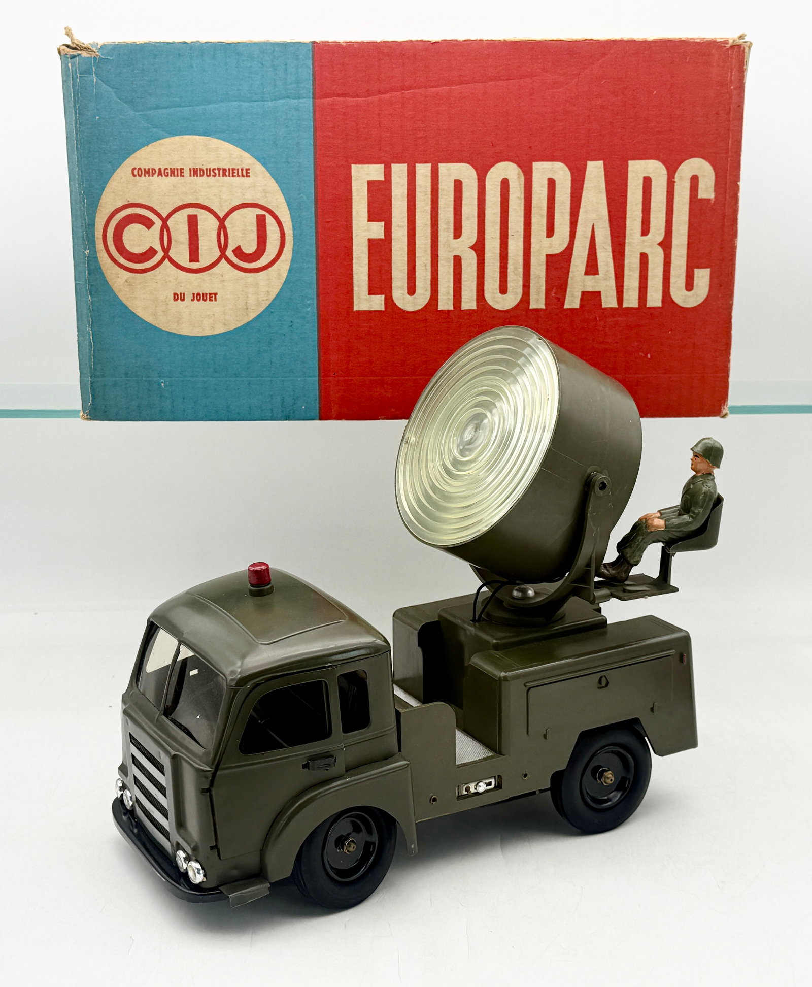 A CIJ Renault Military Europarc Searchlight Truck with Box: This CIJ Europarc military searchlight truck is constructed of pressed steel metal and plastic finished in olive drab. The model features a cab-over-engine design with a red beacon and a rear-mounted 