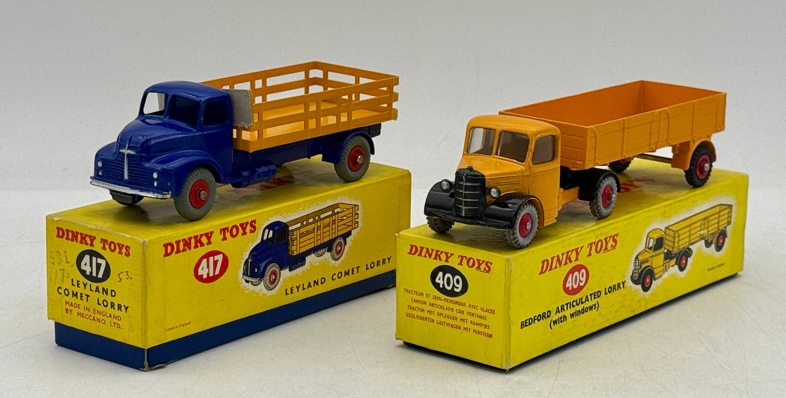 Two Dinky Toys Die-Cast Lorries No. 417 and No. 409: Dinky Toys produced this pair of die-cast metal lorries comprising the No. 417 Leyland Comet and the No. 409 Bedford Articulated Lorry. The Leyland model is finished in blue with a yellow stake bed, w