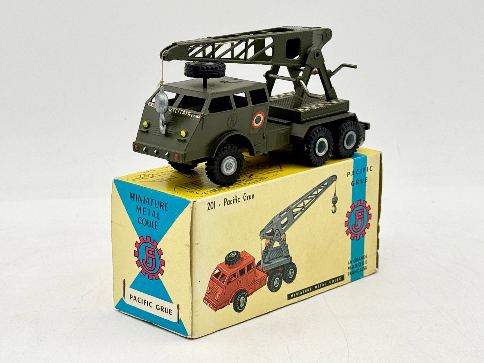 France Jouets No. 201 Pacific Grue Military Die-Cast Toy Crane: This France Jouets No. 201 Pacific Grue is a die-cast metal military crane truck featuring an olive drab finish and a three-axle chassis. The model includes a cab-mounted spare tire and a functional l