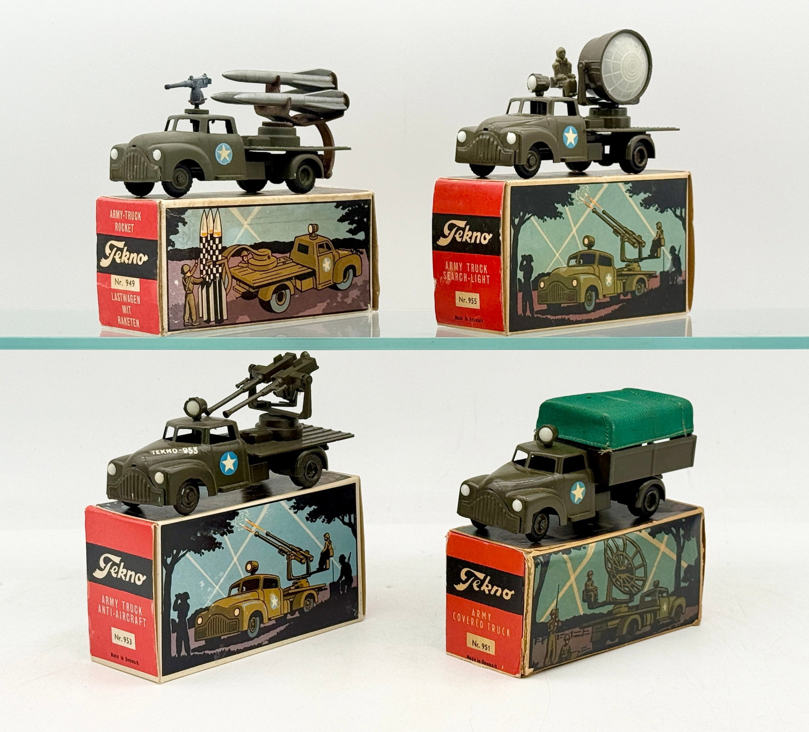 A Collection of Vintage Tekno Die-Cast Military Vehicles with Boxes: A collection of Tekno die-cast military vehicles produced in Denmark, finished in olive drab paint with white-and-blue star insignias. These models are constructed with die-cast metal chassis and plas
