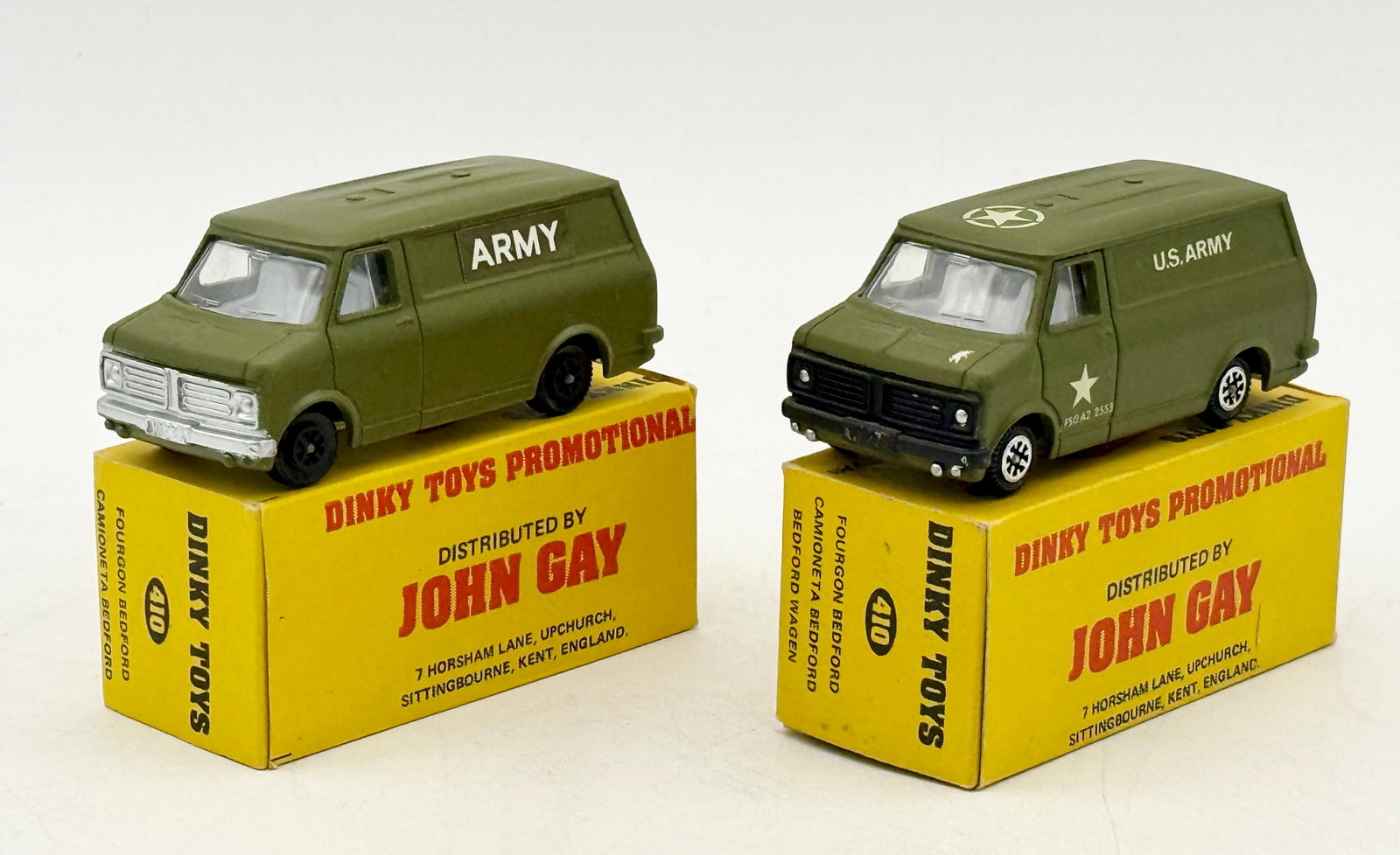 A Pair of Dinky Toys Promotional 410 Bedford Military Vans: A pair of Dinky Toys promotional model 410 Bedford vans manufactured in England by Meccano Ltd. Each die-cast vehicle features an olive green military finish with white lettering and is accompanied by