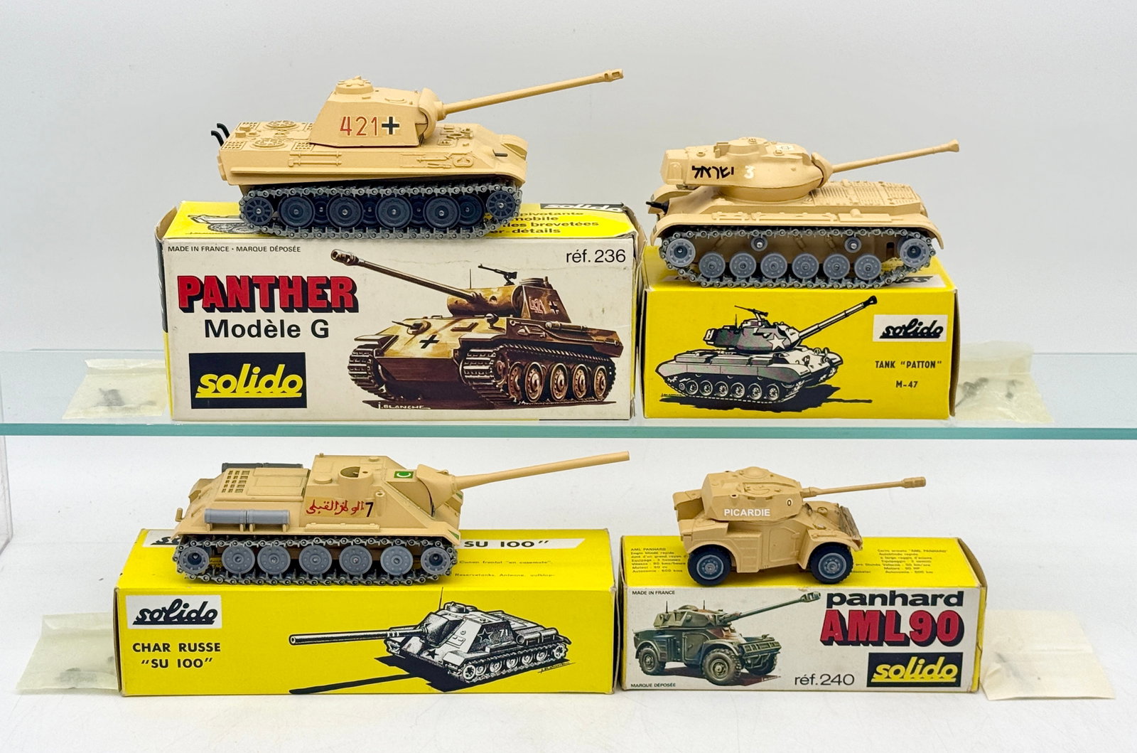 A Collection of Solido Die-Cast Military Tanks and Vehicles: This collection of Solido die-cast military vehicles features a Panther G, M-47 Patton tank, Russian SU 100, and Panhard AML 90. Each model is finished in factory desert tan color paint with original 