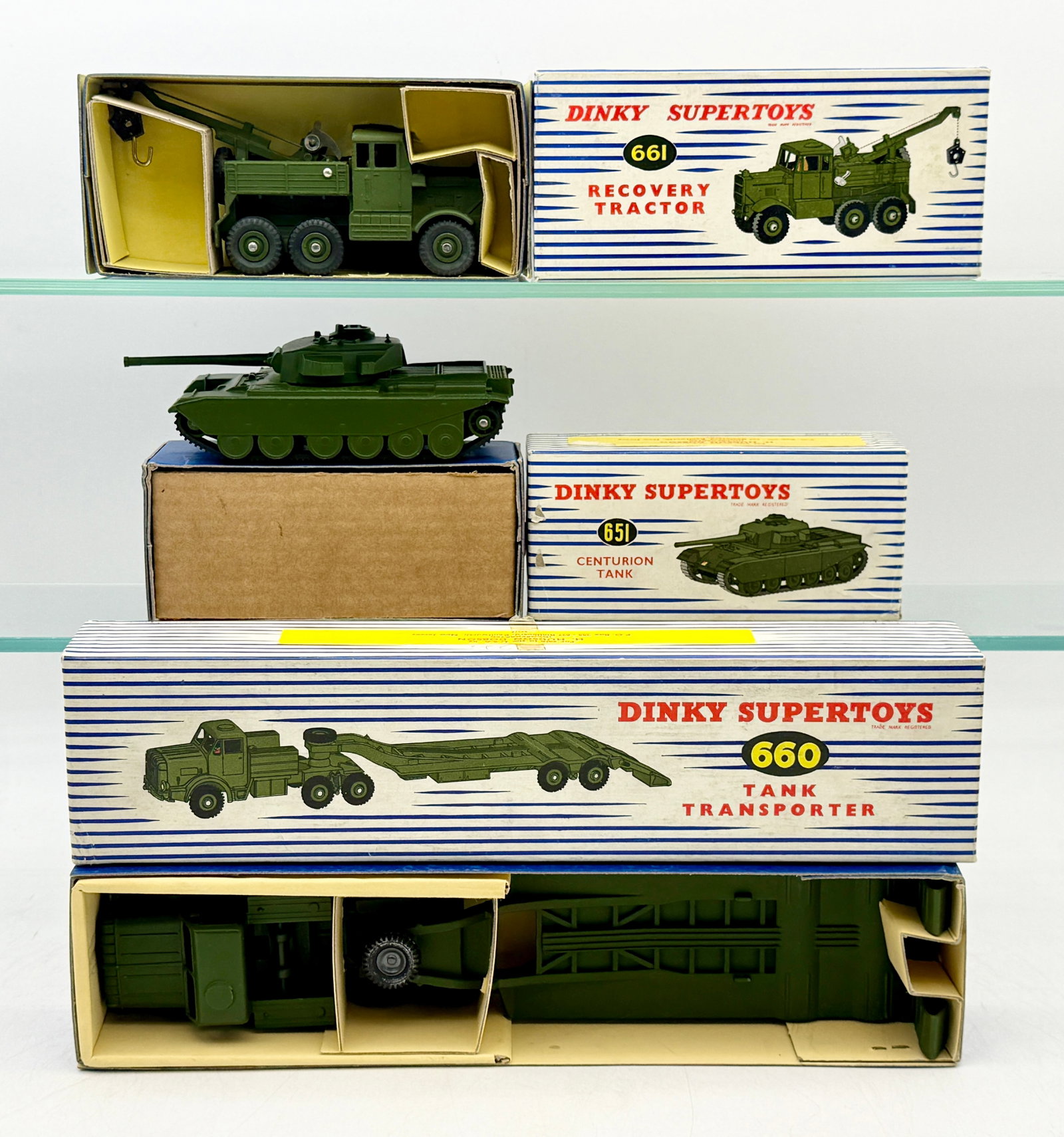 A Trio of Boxed Dinky Supertoys Military Die-Cast Vehicles: Three Dinky Supertoys military models manufactured by Meccano Ltd. in England, including the No. 651 Centurion Tank, No. 661 Recovery Tractor, and No. 660 Tank Transporter. These die-cast vehicles are