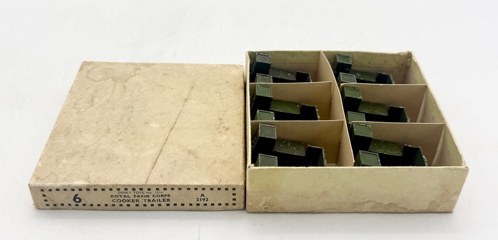 A Collection of Dinky Toys Cooker Trailers with Trade Box: A collection of Dinky Toys No. 151c Royal Tank Corps Cooker Trailers constructed of die-cast metal with an olive green finish. The set is accompanied by a buff cardboard trade box featuring internal d