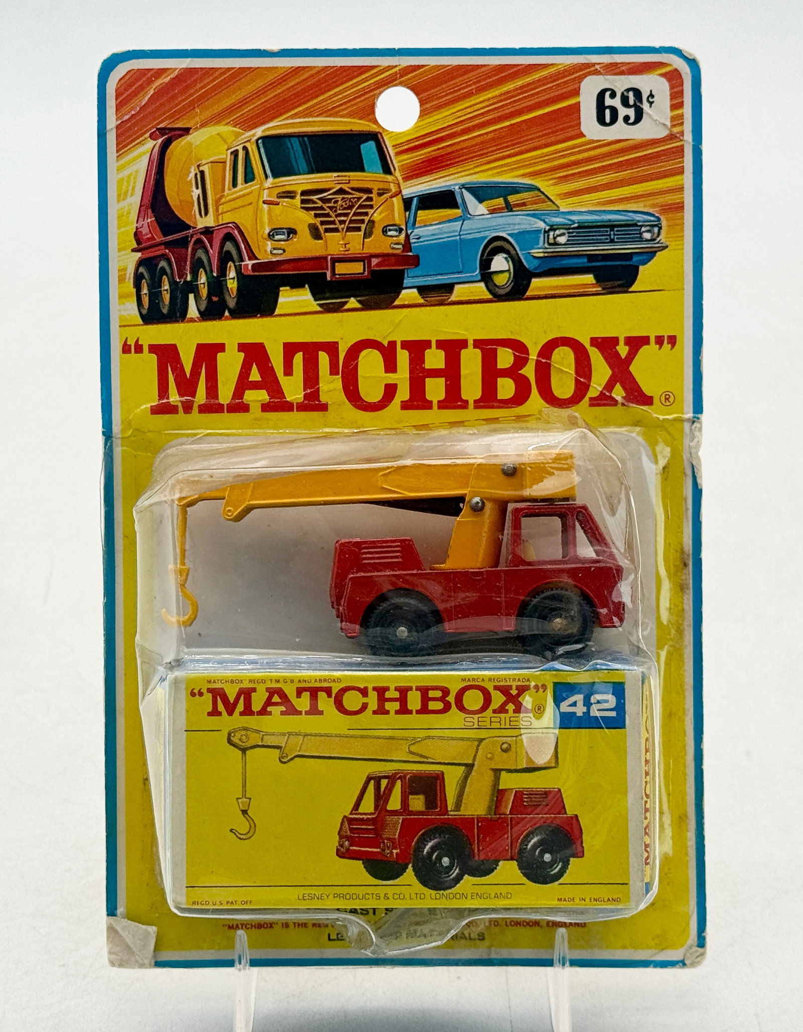 Matchbox No. 42C1 Iron Fairy Crane in Original Blister Pack: This Matchbox Series No. 42C1 Iron Fairy Crane was manufactured by Lesney Products & Co. Ltd. in London. The die-cast vehicle features a red chassis, a yellow crane arm, and black wheels, packaged