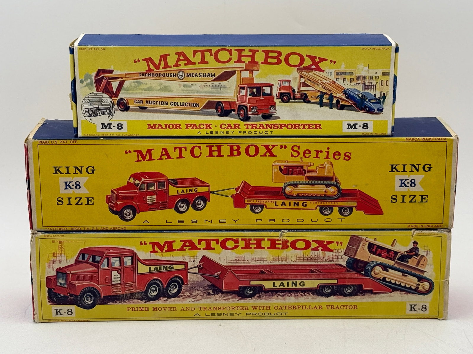 Three Vintage Lesney Matchbox Boxed Commercial Vehicle Model Sets: This collection includes three Lesney Matchbox die-cast metal commercial vehicle sets featuring an M-8B1 Major Pack and two K-8A2 King Size models. The M-8 Car Transporter displays turquoise and red p