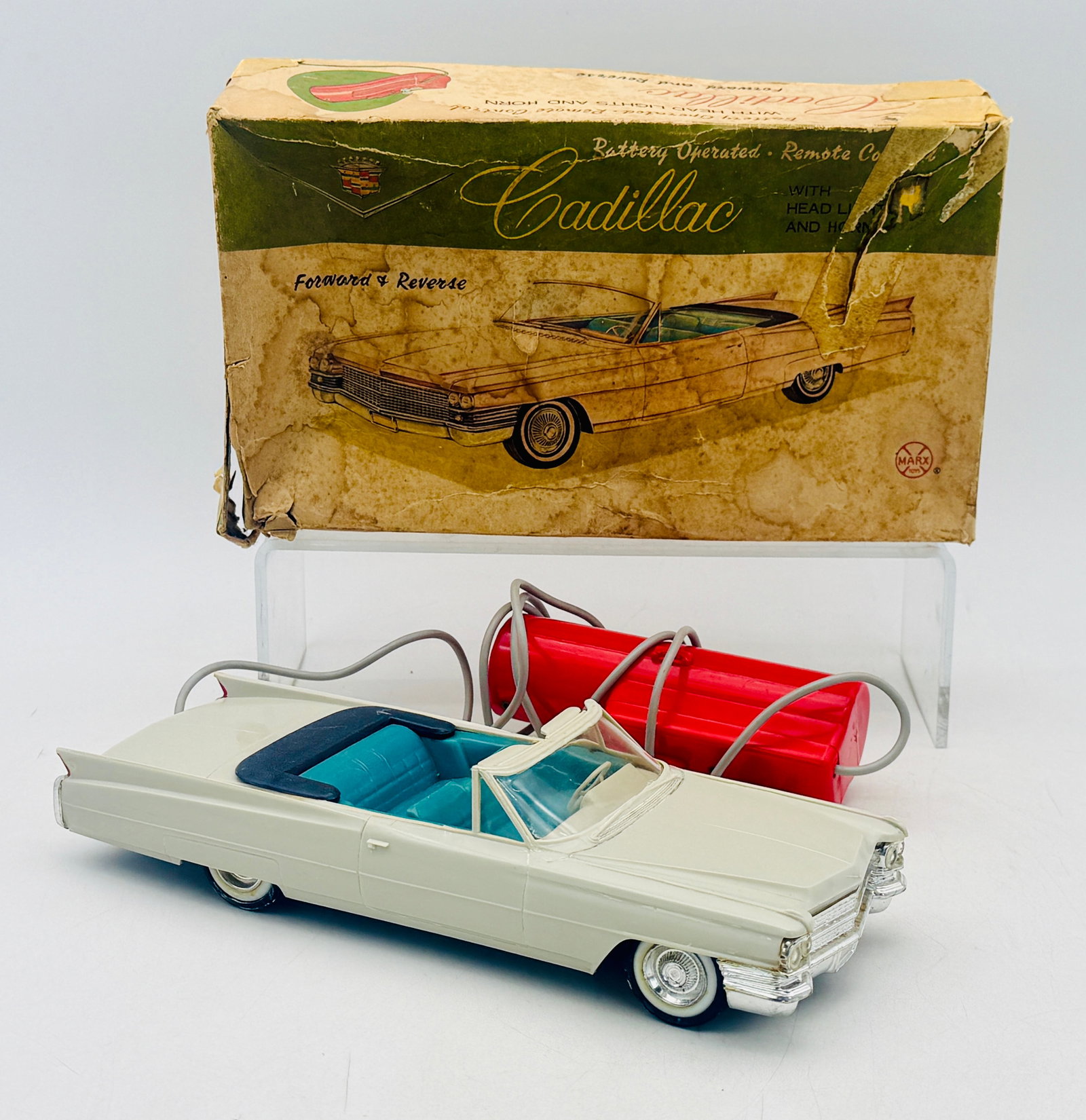 Louis Marx and Company Battery Operated Remote Control 1963 Cadillac: Louis Marx and Company battery-operated remote control Cadillac convertible constructed from molded white plastic with a teal interior and chrome-finished trim. This vintage set features a red plastic