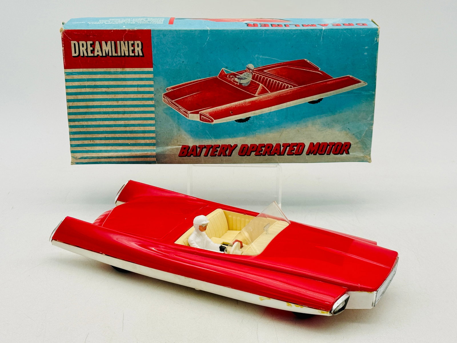 OK Toys #3352 1950s Battery Operated Space Age Dreamliner Car: Qualidux Industrial Company Limited battery-operated plastic Dreamliner concept car featuring a red and white molded body. This vintage futuristic toy includes a functional steering mechanism, a white