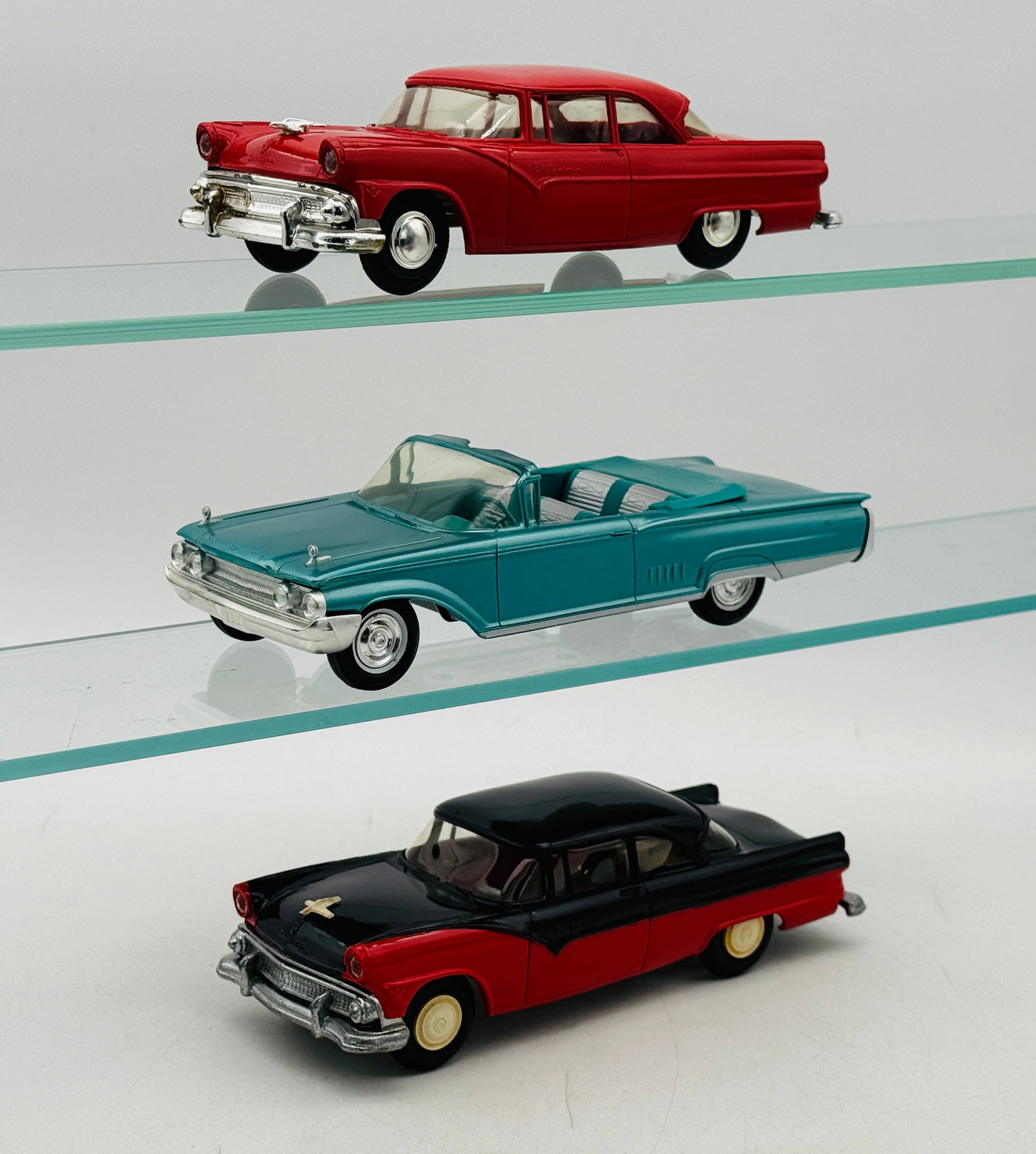 3 AMT Vintage Promotional Model Cars: Three AMT Ford promotional model cars including a 1960 Mercury park lane friction working and two 1955 Fairlane sedans one with metal grille friction working and one with plastic grill coaster (both h