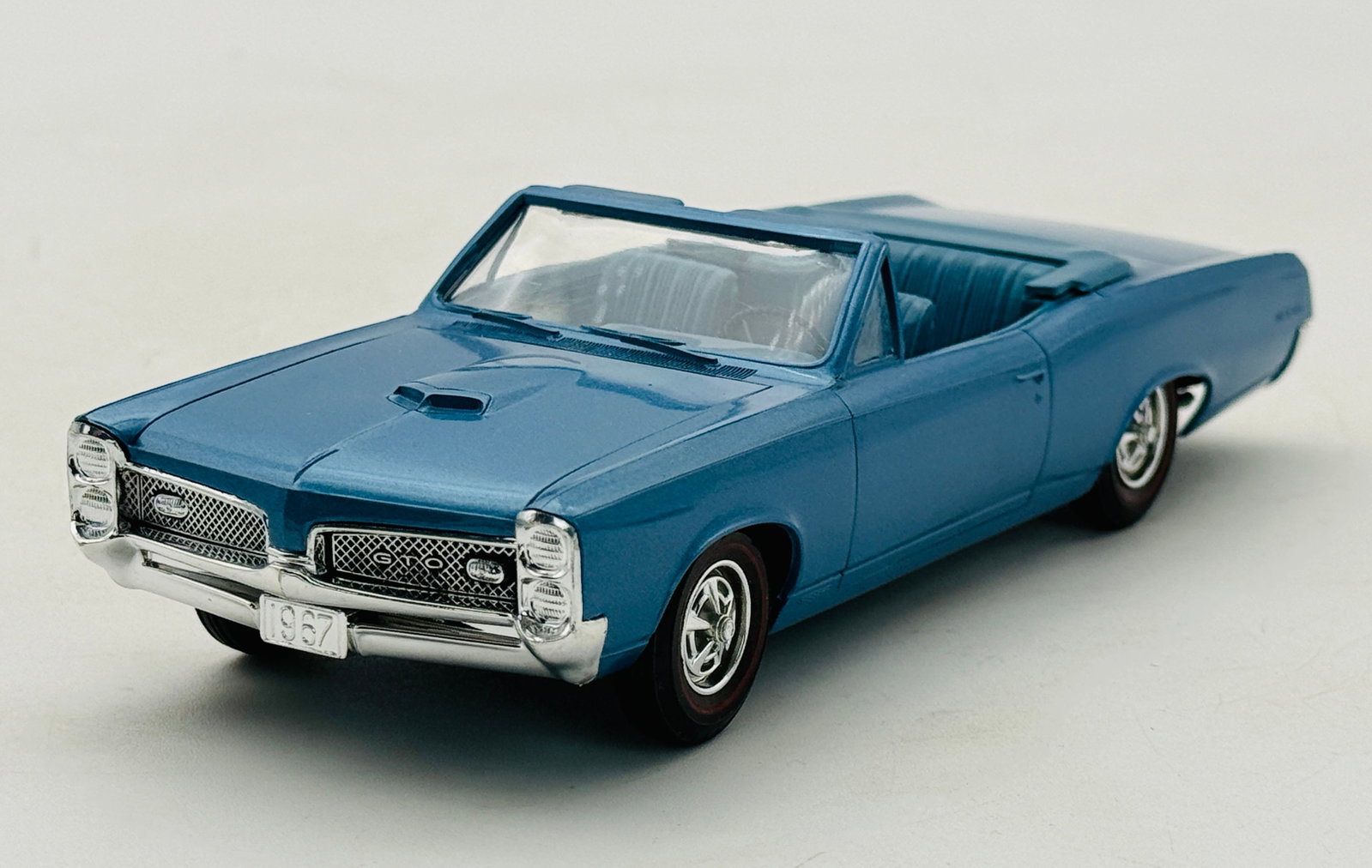 MPC 1967 Pontiac GTO Convertible Model Promo Car: This 1/25 scale model of a 1967 Pontiac GTO convertible is a professionally built kit constructed of plastic and finished in Tyrol blue metallic paint. The vehicle features chrome-plated bumpers, a sp