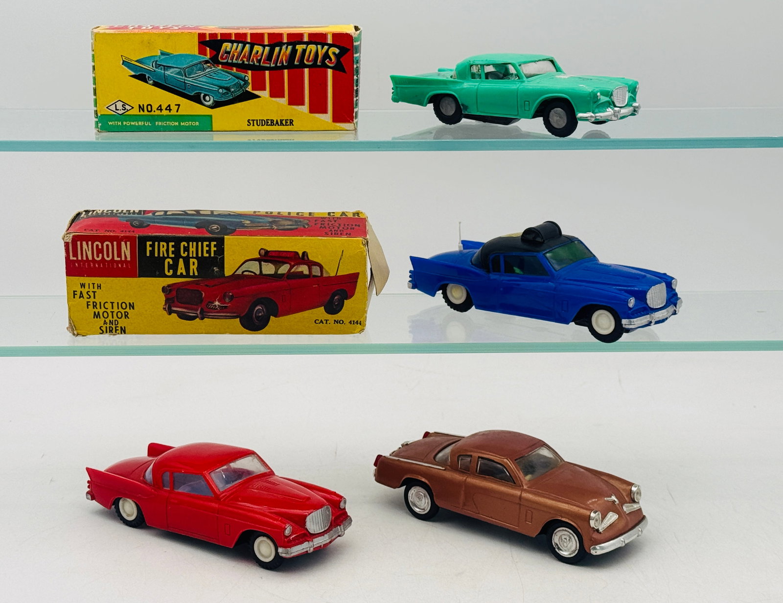 4 Studebaker Hawk Plastic Friction Toy Cars: This collection features four friction-powered plastic model cars based on the Studebaker Hawk, including examples by Charlin Toys and Lincoln International. The set includes a green Charlin model, a 