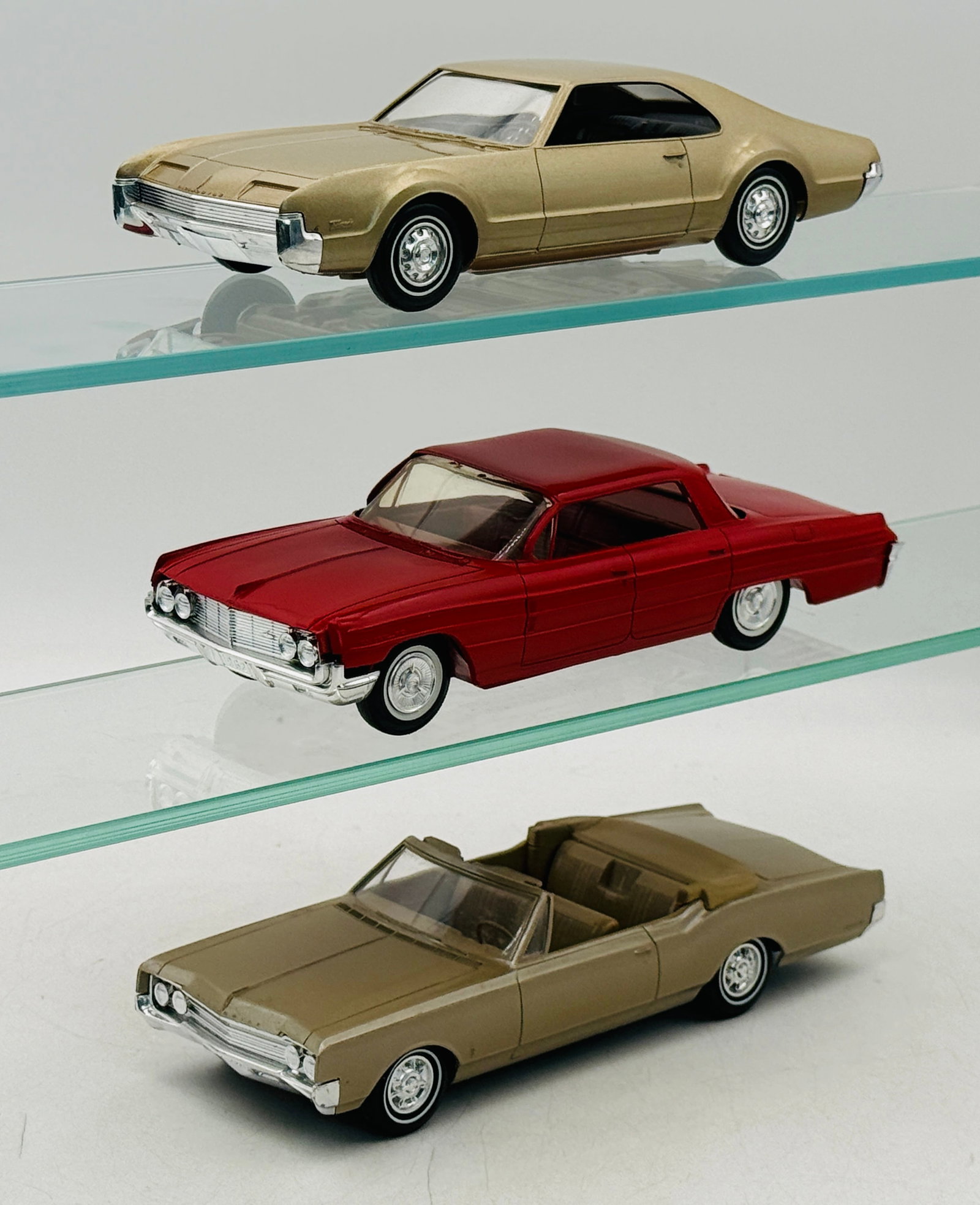 3 Jo-Han/AMT Vintage Promotional Model Cars: Jo-Han and AMT dealership promotional model cars in 1:25 scale, constructed from molded plastic with vacuum-metallized chrome components. This collection includes a metallic gold Jo-Han 1960 Oldsmobil