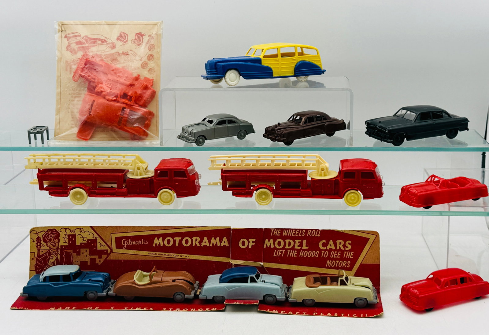 13 Vintage Plastic Toy Vehicles and Kits: This collection consists of injection-molded impact plastic vehicles manufactured by Gilmark Merchandise Corp. of New York. The lot features a Gilmark Motorama of Model Cars four-car display set, two 