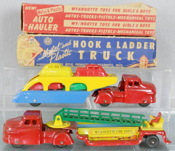 2 WYANDOTTE TRUCKS: pressed steel & plastic, Auto Hauler w/4 cars, 9 1/4" long, Hook & Ladder, 10" long, ladder broken, orig boxes rough, C7.