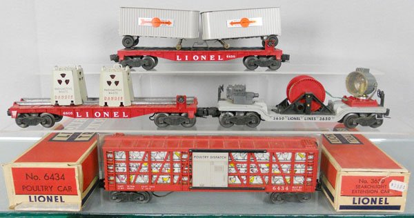 4 LIONEL FREIGHT CARS: O ga, 6430 flat w/trailers, 6805 flat w/radioactive canisters, 3650 searchlight extension, w/crank, 6434 poultry car, 2 orig boxes only, boxes have minor wear, 1 taped, C6-7.