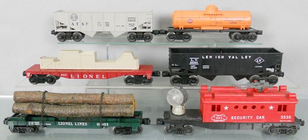 6 LIONEL FREIGHT CARS: O ga, 6076 AT&SF hopper, 6025 Gulf tank car, 6821 flat w/crates, 6476 LV hopper, 6361 log car, 3535 security car, C7-8.