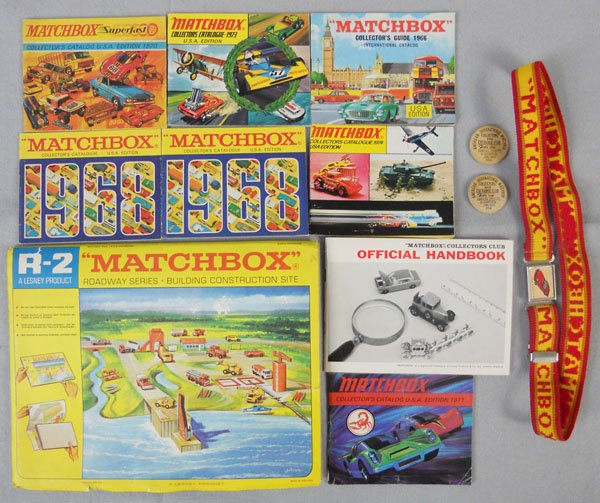MATCHBOX LOT: 2 AIM Coins, R2 Building Construction Site Game Board, outer sleeve torn, Matchbox Belt, catalogs - 1966, 2 1968, 1970, 1971, 1973, 1974, Official Handbook, C8.