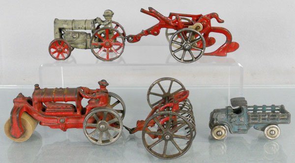 5 ARCADE TOYS: painted cast iron, Fordson Tractor, 3 3/4" long, Oliver Plow, 5 3/4" long, Road Roller, 5 1/4" long, Hay Rake, 3 1/2" long, Mack Stake Truck, 3 1/2" long, C5.