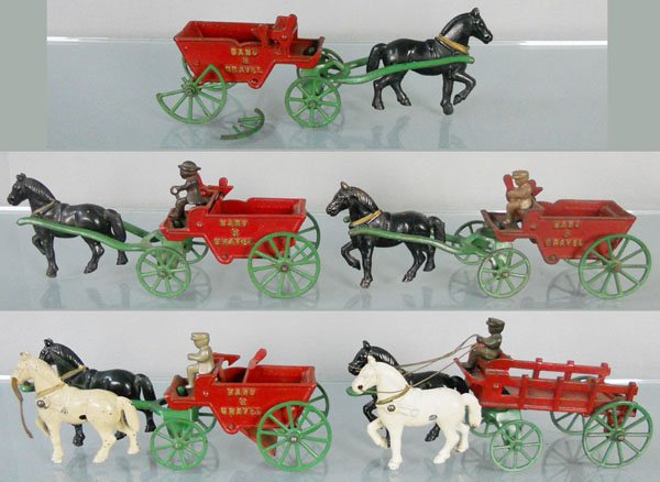 5 KENTON WAGONS: painted cast iron, 4 Sand & Gravel Wagons, 10 1/2" long, 1 has a broken wheel, Stake Wagon, 10 1/2" long, missing 1 driver, C6-7.