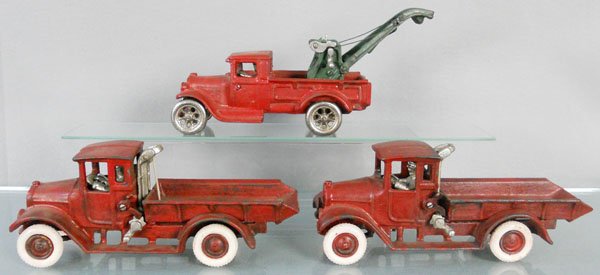3 TOY TRUCKS: painted cast iron, Wrecker, 11" long, 2 Dump Trucks, 10 1/2" long, all are reproduction Arcade trucks, C6.