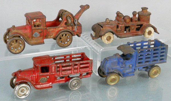 4 TOY TRUCKS: painted cast iron, Arcade Wrecker, 5" long, boom broken, Stake Truck, 4 3/4" long, Kilgore Fire Engine, 5" long, grille broken, tires worn, Hubley Mack Stake Truck, 4 1/4" long, C2-5.