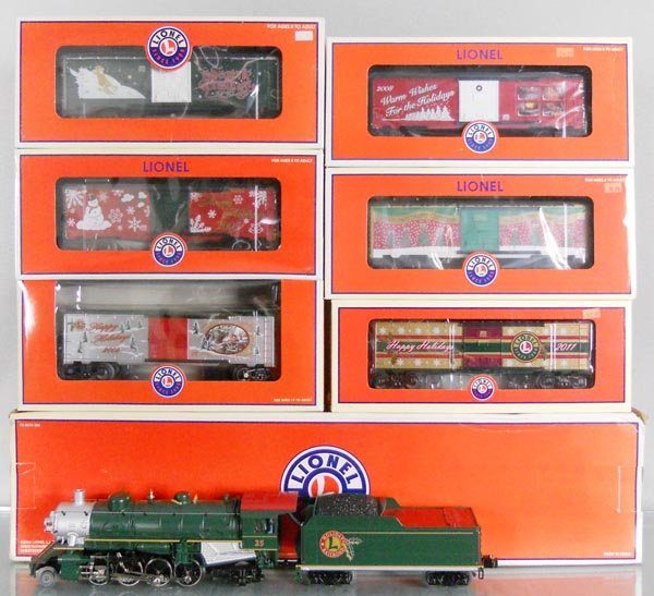 LIONEL CHRISTMAS TRAIN SET: O ga, 38626 Holiday Mikado Jr. loco & tender, green, w/sound & smoke, w/29975 2011, 36296 2005, 19998 2001, 25066 2009, 250061 2008 & 25008 2006 annual Christmas box cars, orig boxes, C10.
