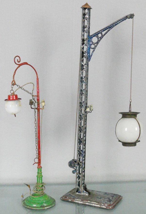 2 BING LAMP POSTS: litho tin, one is 11” tall, other is a girder lamp post, 15 1/2” tall, missing catch for handcrank, weight added to bottom of base, glass intact, paint flaking, C4-5.