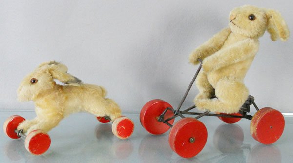 2 STEIFF RABBITS ON WHEELS: 8 1/2” & 9” long, both have buttons in ears, squeaker not working on larger one, C5-7.