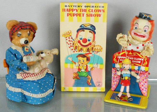 2 Y OF JAPAN TOYS: litho tin & plastic, cloth dressed, battery operated, not working, Bear Feeding Baby, 9” tall, Happy the Clown Puppet Show, 10” tall, w/orig box, C6-8.
