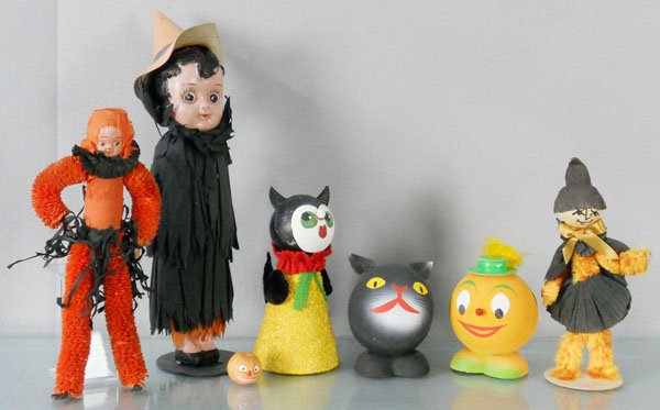 7 HALLOWEEN DECORATIONS: 3 West German Candy Boxes, celluloid Carnival Doll, 2 Halloween figures, composition Pumpkin Head, tallest is 14”, C6-8.