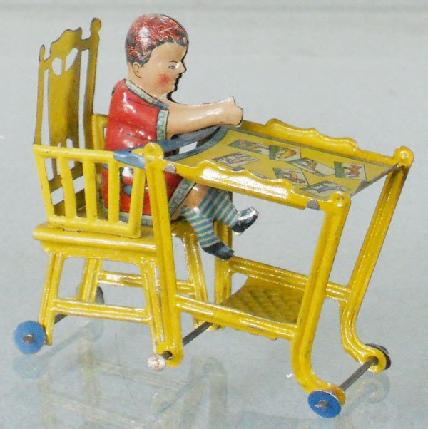 FISCHER BOY IN HIGH CHAIR PENNY TOY: litho tin, 4” tall, C7.
