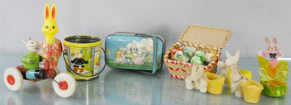 9 EASTER DECORATIONS: wooden Tricycle, 5” long, 2 Peter Rabbit tins, 1 missing top, plush Chicks in Basket, 5 Candy Containers, C5-7.