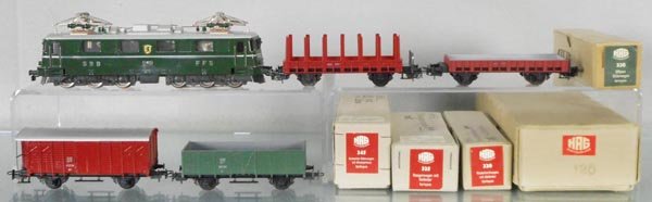 HAG FREIGHT TRAIN SET: HO ga, 3-rail, 120 electric loco, green, 32 stake car, brown, 320 flat, brown, body separated from frame, 345 box car w/house, brown, 330 hopper, green, orig boxes, 2 w/graffiti, C8-9.