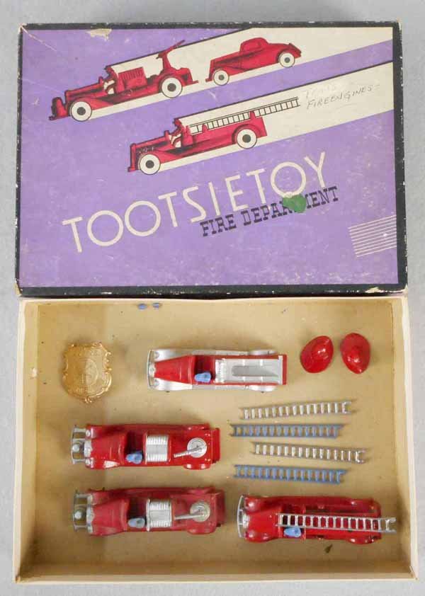 TOOTSIETOY 411 FIRE DEPARTMENT: contains 1040 Hook & Ladder, 2 #1041 Hose Cars, 1042 Insurance Patrol w/badge, 2 Hats & 3 extra ladders, orig box minor wear, C7-8.