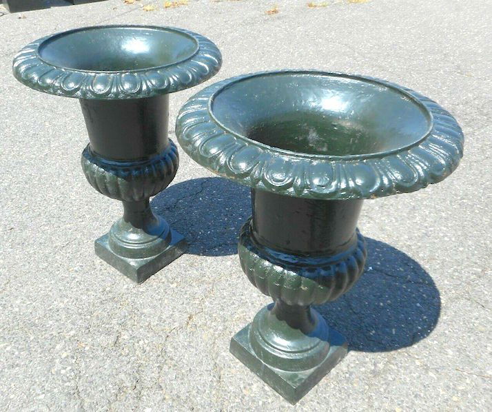 Cast Iron Urns: Beautiful pair of cast iron urns. Sturdy construction with a green painted finish. Decorative trim around the lip of the urn and the body give this pair a great look. Sure to prove a great addition to