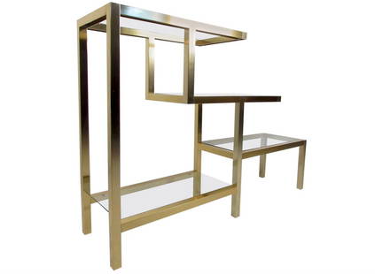 Vintage Modern Low Bookshelf after Milo Baughman: Vintage-modern Milo Baughman style bookcase featuring sculpted body with brass finish and four glass shelves. Stunning display shelf for home, office, or business use.Please confirm item location NY o