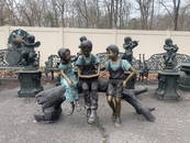 Bronze Statue Of Children Sitting On Log