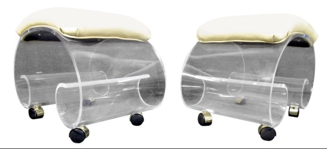Pair of Mid-Century Rolling Lucite Benches: Pair of Lucite vanity stools featuring a spiral bottom sitting on four rolling wheels in a bronze finish. The top also has a square vinyl pad. // PICKUP LOCATION: BROOKLYN, NY // DIMENSIONS: Height: 1