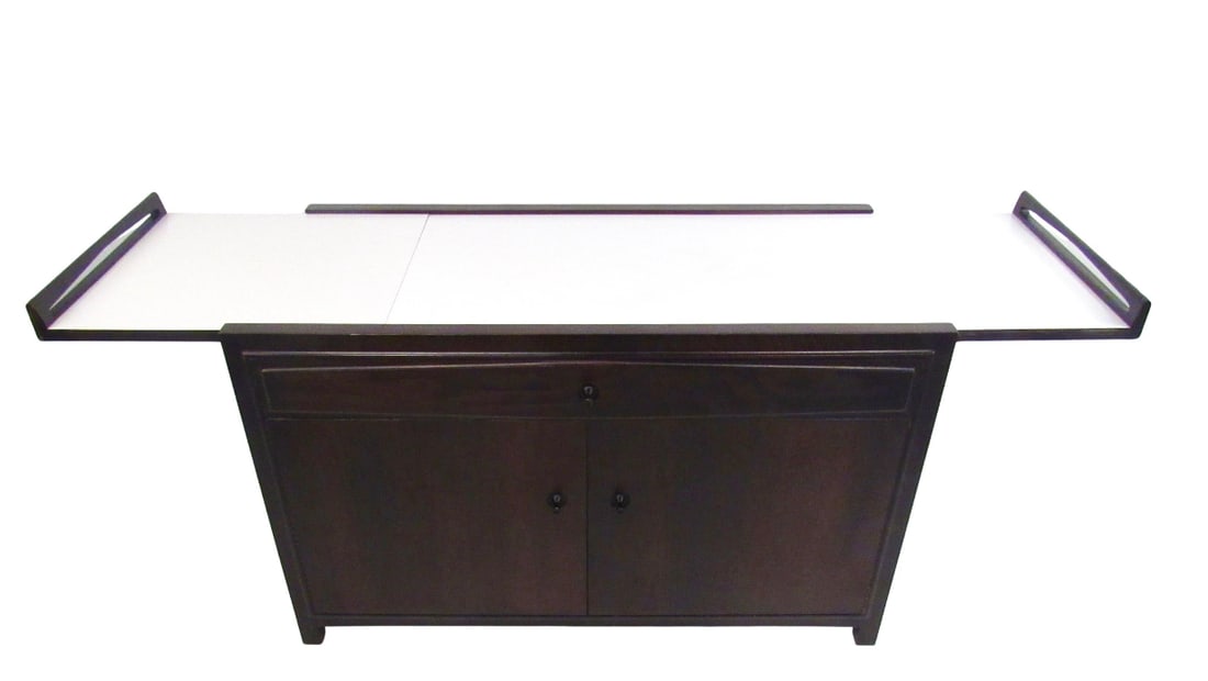 John Kapel for Glenn of California Expandable Bar Cart Cabinet: This unique Mid-Century bar cabinet features an expandable formica top with raised edges, spacious storage shelves, and a wide drawer for organizing glass ware or other items. Made by John Kapel for G