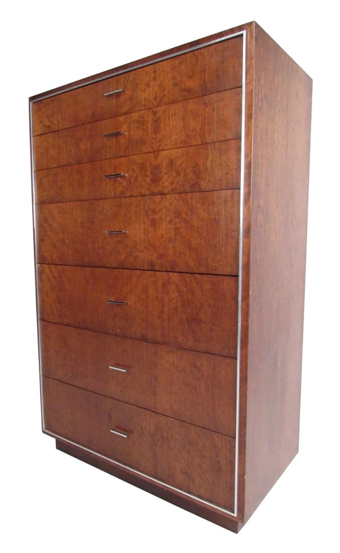 Tall Midcentury Highboy Dresser by John Stuart Inc: This tall midcentury dresser by John Stuart Inc. features warm walnut tones accented by aluminium trim and chrome drawer pulls. This substantial mid-century highboy makes an impressive dresser in any