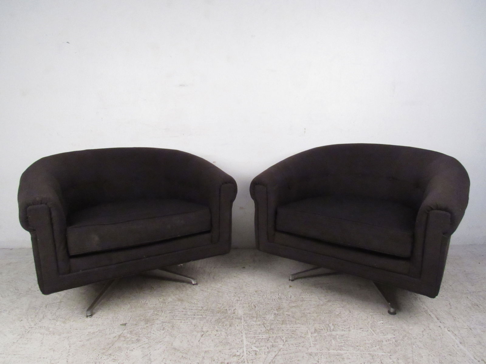 Pair of Mid-Century Style Swivel Lounge Chairs by Selig: This comfortable pair of swivel style lounge chairs by Selig make a stylish addition to any setting. Rounded back seats with sturdy metal bases, this unique matching pair is perfect for home or office