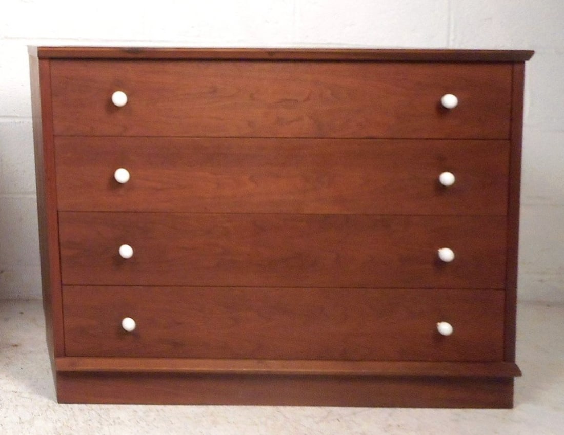 Mid-Century Chest of Drawers: Sturdy construction consisting of finished walnut grain. Sleek round white drawer pulls. Four spacious drawers with dovetail-joint construction signifying quality craftsmanship. // PICK UP