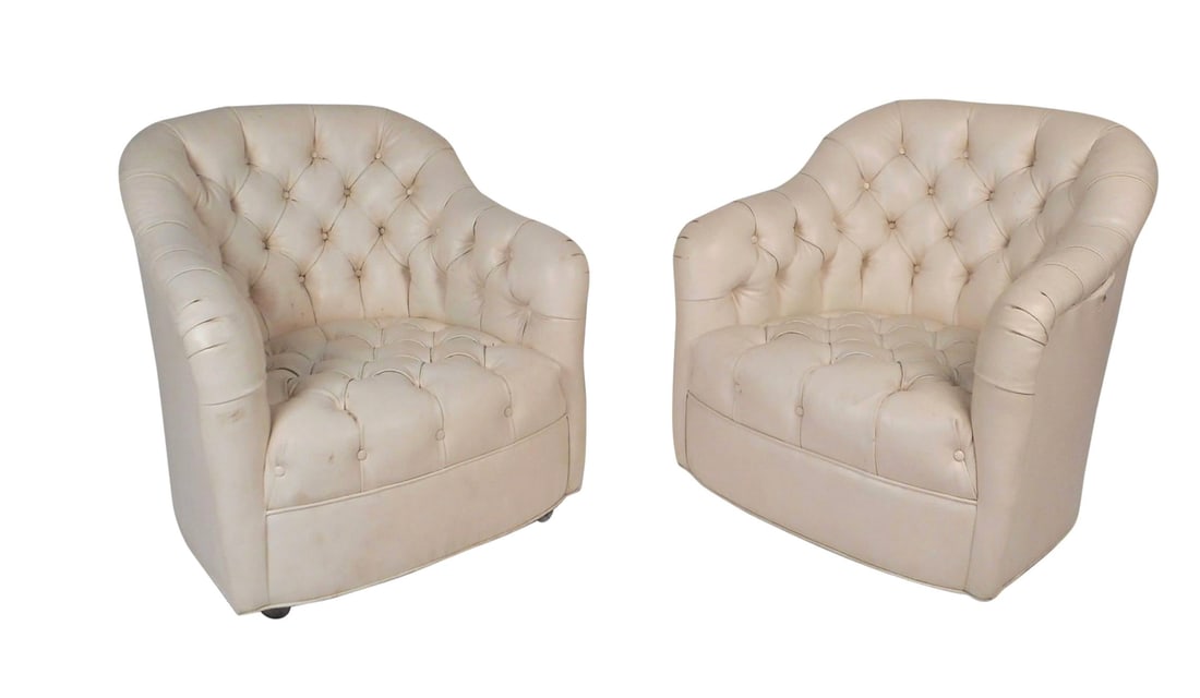 Pair of Mid-Century Modern Tufted Vinyl Lounge Chairs: Stunning pair of vintage modern lounge chairs covered in white tufted vinyl. This wonderful pair has a comfortable barrel backrest with sloping arm rests. These stylish chairs have thick padded