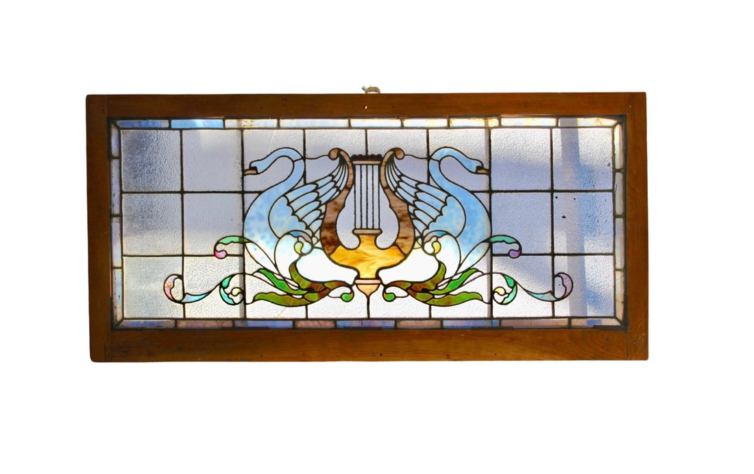 Architectural Stained Glass Window with Swans: This stunning window features detailed leaded designs of two swans and harp within the checkered background. The glass is textured and some is marbled, with an additional border beneath the wood