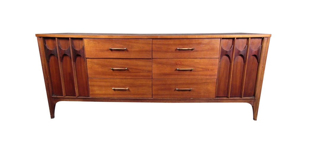 Mid-Century Modern Walnut Server by Kent Coffey: This Mid-Century Modern server by Kent Coffey features rich walnut woodgrain, brass and wooden accents, and abundant storage with twelve drawers. The server has six center drawers with brass handles,