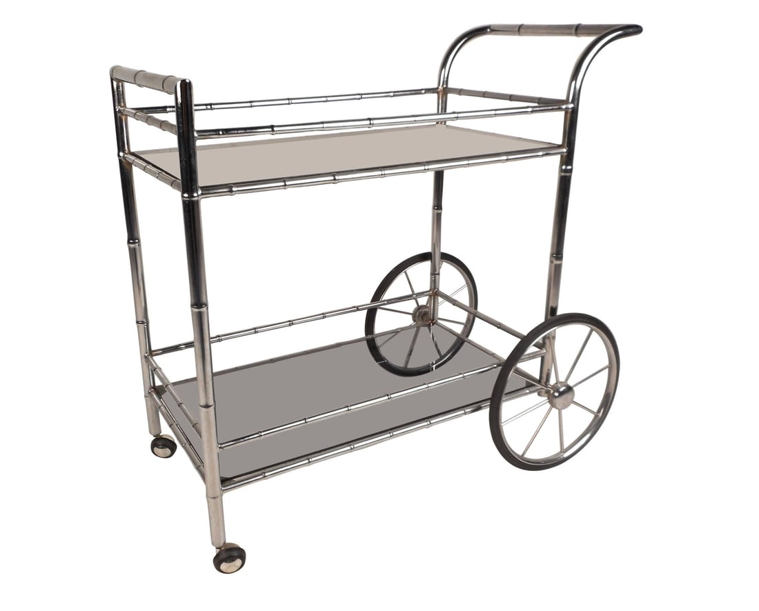 Vintage Modern Bar Cart in Faux Bamboo Finish: Sleek vintage modern bar cart with a faux bamboo chrome frame, large spoked wheels, and smoked glass shelves. The gorgeous two-tier design features extra stretchers to prevent items from falling off w