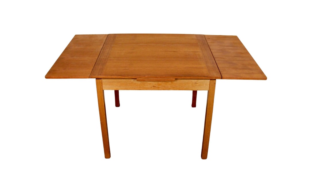 Miniature Danish Teak Draw-Leaf Table: Compact Danish modern teak drop-leaf table featuring clean minimalist lines and warm, well-figured teak surfaces. The table’s dual hinged leaves fold neatly down to create a slim profile, making it