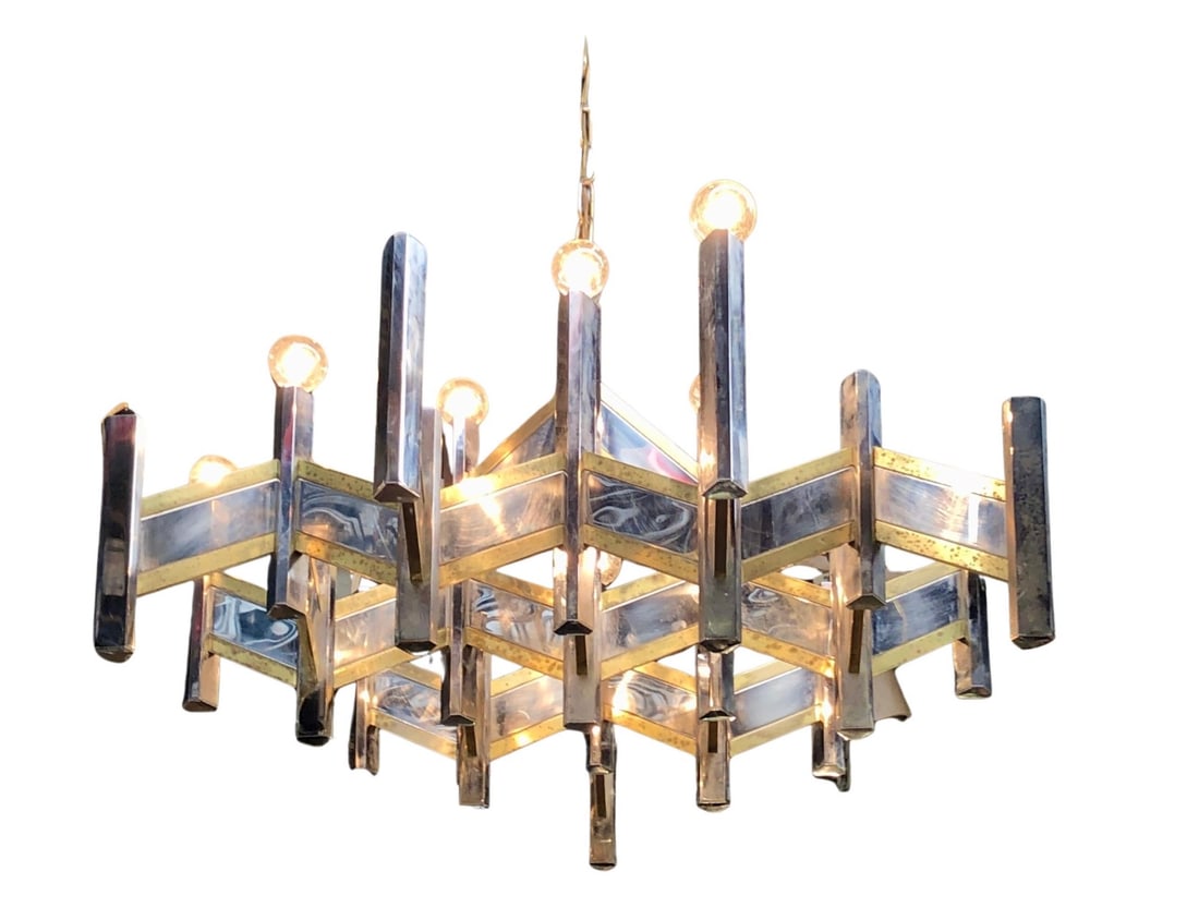 'Concorde' Chandelier by Gaetano Sciolari: Distinctive geometric chandelier crafted in polished chrome with elegant brass trim accents. The bold angular design blends modernist structure with warm metallic detail, creating a striking focal poi
