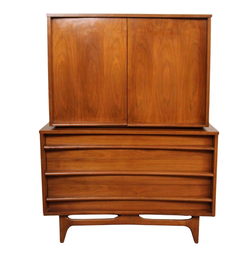 Mid-Century Concave Highboy Dresser by Young Manufacturing Co.: Handsome two piece mid-century highboy dresser by Young Manufacturing Co., crafted from richly grained walnut with the brand’s signature sculpted drawer fronts. Featuring six spacious drawers and