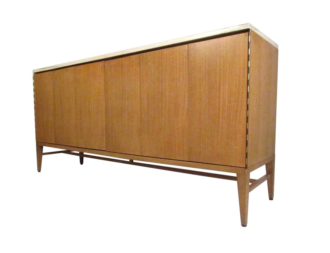 Mid-Century Modern Dresser by Paul McCobb: A beautiful vintage modern sideboard by Paul McCobb with a sleek marble top. This stunning case piece offers plenty of room for storage within its many drawers hidden by unique folding doors. Quality